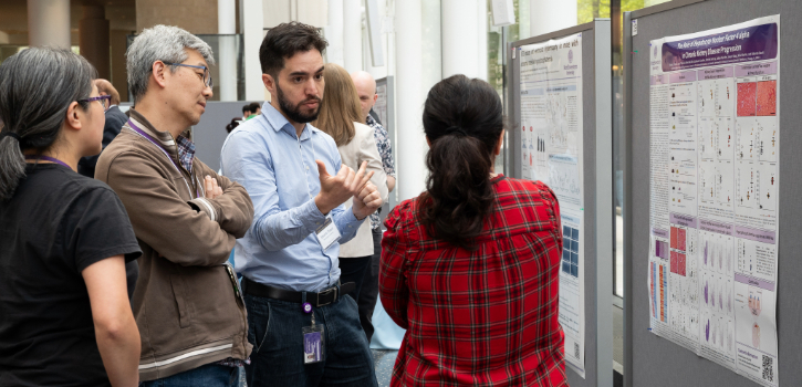A trainee shows a viewer the details of their poster