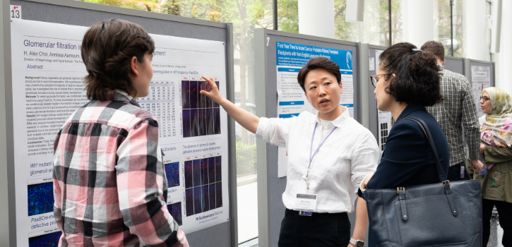 A trainee shows a viewer the details of their poster