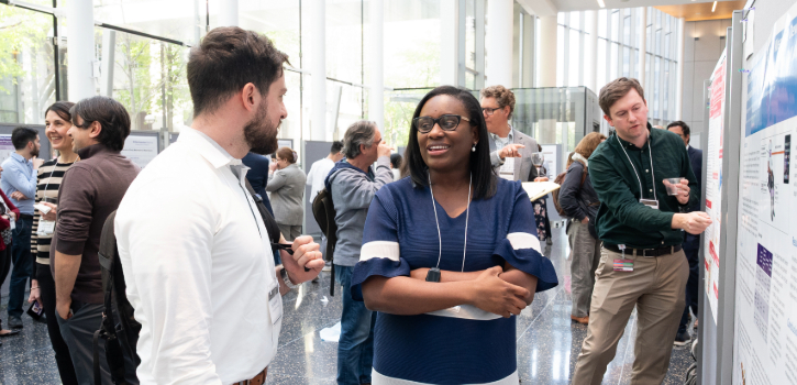 A trainee shows a viewer the details of their poster