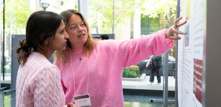 A trainee shows a viewer the details of their poster
