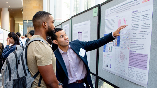 Two people looking at a health equity research poster together .