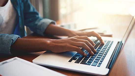 Someone typing on a laptop keyboard