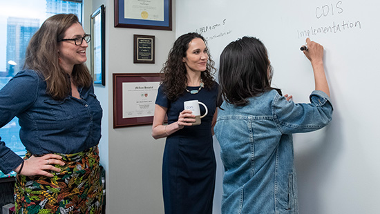 cdis members writing on a whiteboard