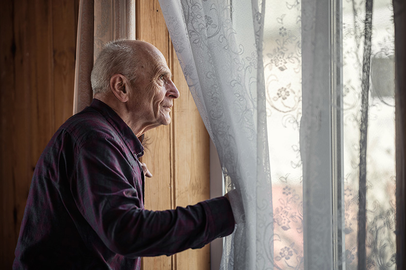 elderly man looking out window