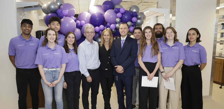 Twelve people standing in front of purple balloons in the new center for neurogenomics