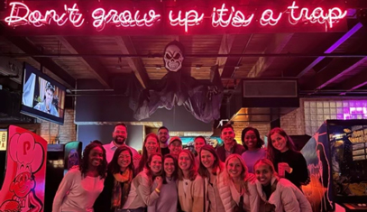 A group of current residents under a pink neon sign.