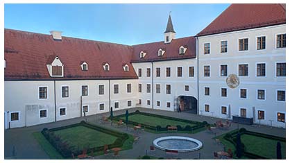 Image a white building with a red roof, a monastery