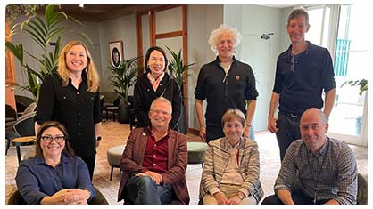 Image of six individuals, four sitting and four standing.