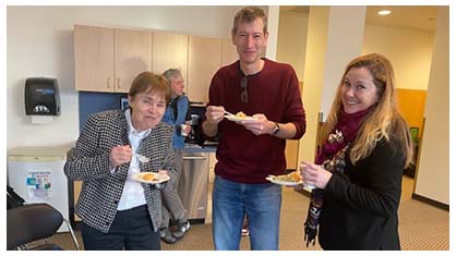 Image of three people conversing over a meal